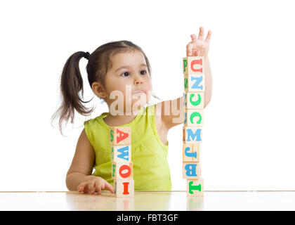 La petite fille jouant les jouets en bois Banque D'Images