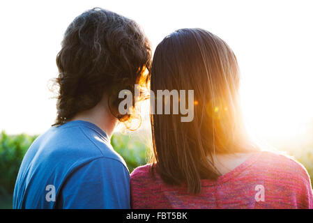 Jeune couple regardant le coucher du soleil Banque D'Images