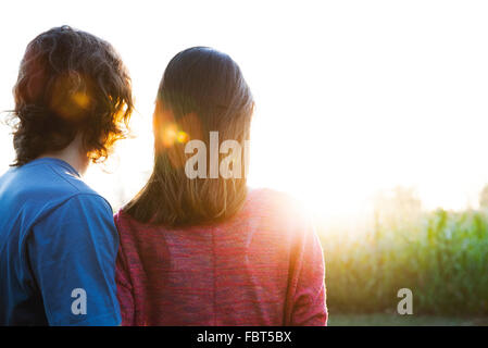 Jeune couple regardant le coucher du soleil Banque D'Images