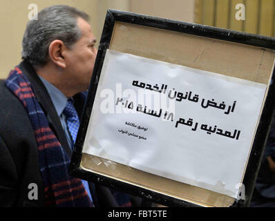 Le Caire, Égypte. 19 Jan, 2016. Saïd Okacha Tawfiq, un présentateur de télévision qui a été élu au parlement, est assis dans une antichambre et détient des banderoles contre le droit de la fonction publique au cours d'une session parlementaire, au Caire (Egypte) en 19 janvier 2016 © Amr Sayed/APA/Images/fil ZUMA Alamy Live News Banque D'Images