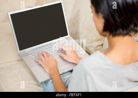 Plus d'épaule de brunette using laptop Banque D'Images
