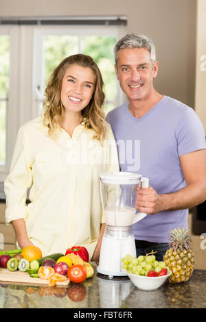 Smiling couple préparer smoothie sain Banque D'Images