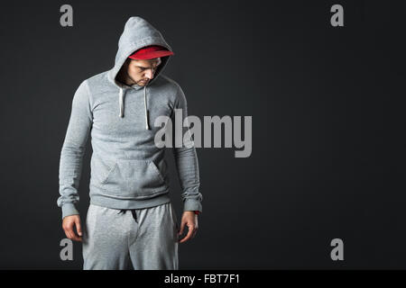 Studio portrait de jeune mec cool à la recherche dans les vêtements de sport. Banque D'Images