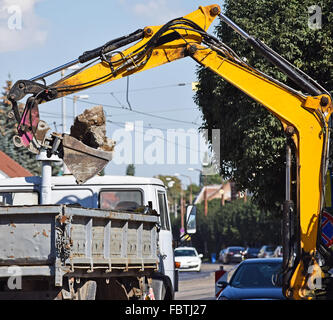 Travaux publics pelle à la construction de routes dans la ville Banque D'Images