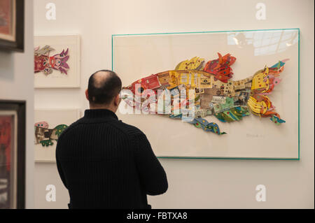 Londres, Royaume-Uni. 19 janvier, 2016. . Un homme vues un collage de vieux paquets de cigarettes sous la forme d'un poisson à l'occasion de la London Art Fair, the UK's premier ministre britannique moderne et juste pour l'art contemporain, qui a lieu à du Business Design Centre à Islington. Maintenant dans sa 28e année, le salon met en vedette une variété de travaux d'artistes britanniques et internationaux et les photographes. Crédit : Stephen Chung / Alamy Live News Banque D'Images