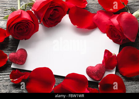 Saint-valentin : Concept vide blanc carte papier, roses et pétales de roses sur fond de bois rustique. Banque D'Images