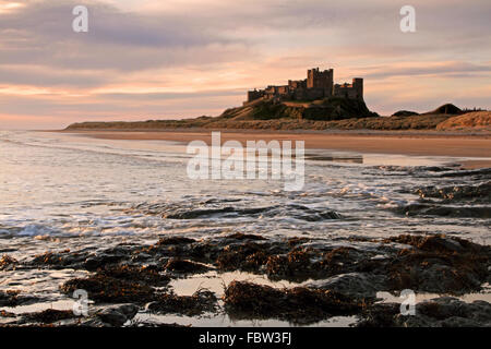 Lever du soleil sur le château de bamburgh. Construit sur un affleurement de dolérite et situé sur la côte de Northumberland en Angleterre Banque D'Images