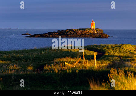 Phare sur petite île au lever du soleil, l'île de Flatey, l'Islande, l'Europe. Banque D'Images