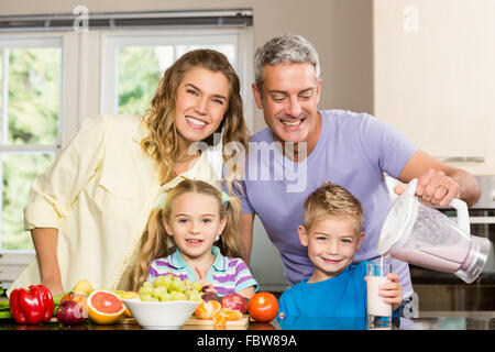 Famille heureuse préparer smoothie sain Banque D'Images