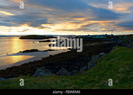 Littoral et les bâtiments sur Flatey au lever du soleil, l'île de Flatey, l'Islande, l'Europe. Banque D'Images