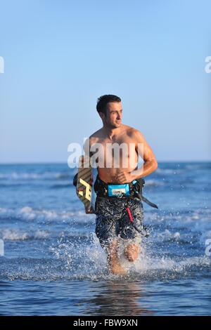 Portrait d'un jeune homme sur la plage de kitsurf au coucher du soleil Banque D'Images