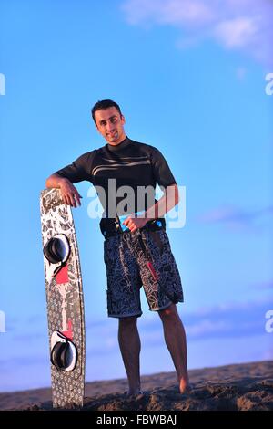 Portrait d'un jeune homme sur la plage de kitsurf au coucher du soleil Banque D'Images