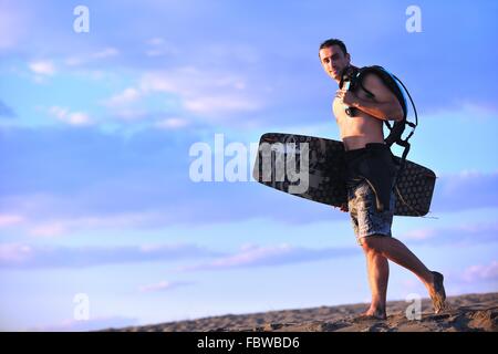 Portrait d'un jeune homme sur la plage de kitsurf au coucher du soleil Banque D'Images