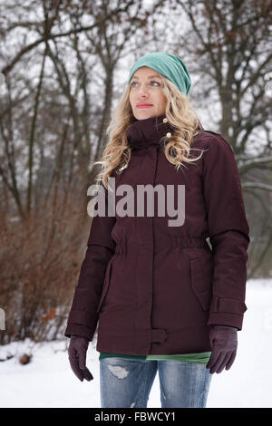Blonde woman in snowy forest Banque D'Images