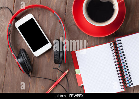 Office de bureau en bois avec le bloc-notes, tasse à café, smartphone et écouteurs. Top View with copy space Banque D'Images