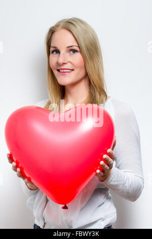 Blond Woman Holding a heart Balloon Banque D'Images