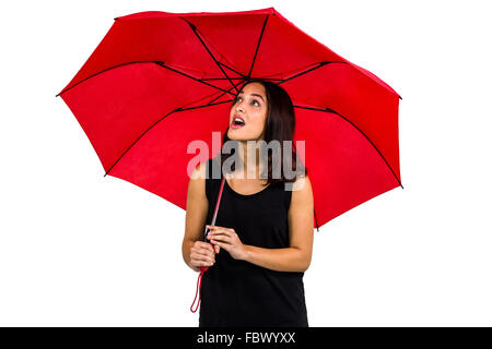 Choqué à la femme tout en maintenant le parapluie rouge Banque D'Images