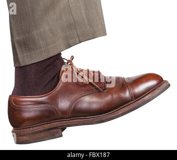 Vue latérale de la jambe droite mâle brown shoe en fait un pas isolé sur fond blanc Banque D'Images
