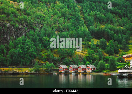 Les quais de bois rouge dans la petite ville touristique de Flam sur le côté ouest de la Norvège dans les fjords profonds. Arrière-plan de la forêt Banque D'Images