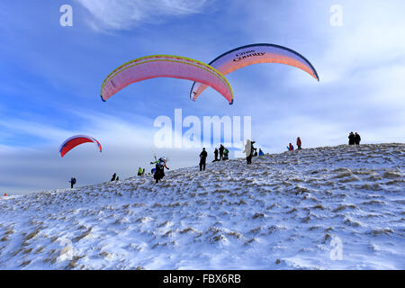 Parapentes sur le point de décoller de Mam Tor enneigé près de Castleton, Derbyshire, Peak District National Park, Angleterre, Royaume-Uni. Banque D'Images