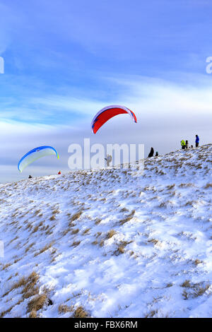 Parapentes sur le point de décoller de Mam Tor enneigé près de Castleton, Derbyshire, Peak District National Park, Angleterre, Royaume-Uni. Banque D'Images