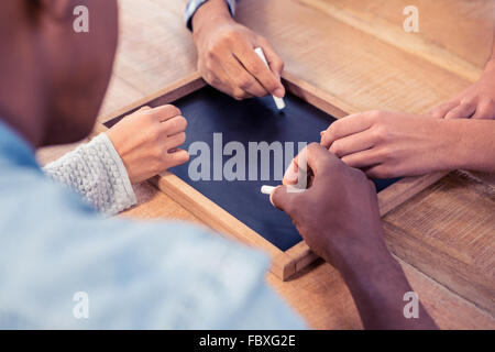 Les mains coupées des gens d'affaires écrit sur l'ardoise à 24 Banque D'Images