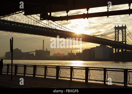 Le soleil se lève sous le Manhattan Bridge enjambant la rivière de l'est rejoindre Manhattan à DUMBO, Brooklyn Banque D'Images