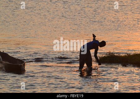 Pêcheur au coucher du soleil sur la rivière Chobe entre le Botswana et la Namibie, l'Afrique Banque D'Images