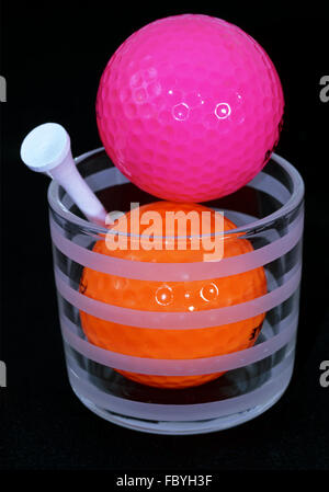 Balles de golf orange et violet avec tee blanc Banque D'Images