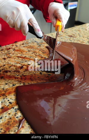 Les sucreries femme chocolat tempérer le chocolat sur une table de marbre froid Banque D'Images