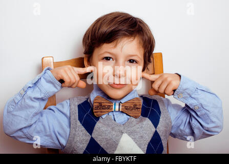 Peu cute boy dans bowtie smiling, making funny faces Banque D'Images