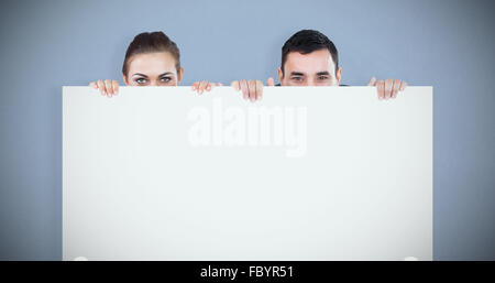 Image composite de partenaires d'affaires de se cacher derrière un signe Banque D'Images