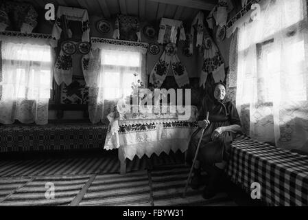 Femme âgée assis dans leur maison dans un village dans le district de Maramures, Roumanie Banque D'Images