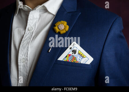 Homme portant un costume bleu, veste Broche fleur et, tenant le roi pique dans la poche, concept casino Banque D'Images