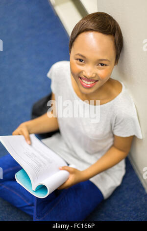 Vue de dessus de happy African college girl reading a book Banque D'Images