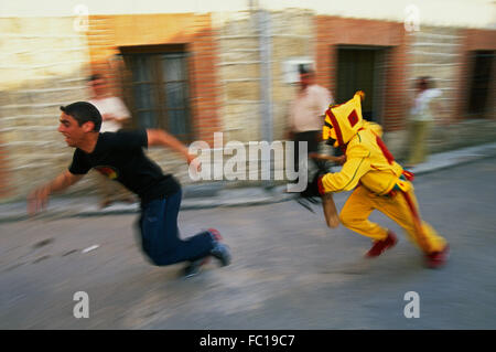 El Colacho chasse les jeunes du village avec son fouet au cours de la Fiesta del Colacho à Castrillo de Murcia, Burgos, Espagne Banque D'Images