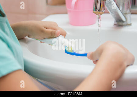 Fillette de six ans se lave et brosses les dents dans la salle de bains Banque D'Images