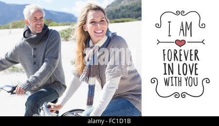 Image composite de carefree couple partir en promenade en vélo sur la plage Banque D'Images