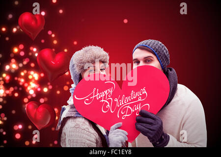 Composite image jeune couple dans des vêtements chauds holding red heart Banque D'Images