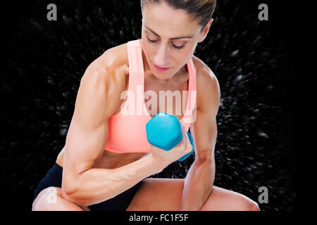 Image composite d'une femme forte de bicep faire avec haltère bleu Banque D'Images