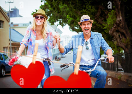 Image composite du hip young couple going for a bike ride Banque D'Images