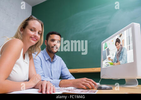 Image composite de l'artiste quelque chose de dessin sur tablette graphique avec des collègues derrière Banque D'Images