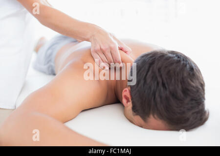 Physiothérapeute massage épaule faisant de son patient Banque D'Images