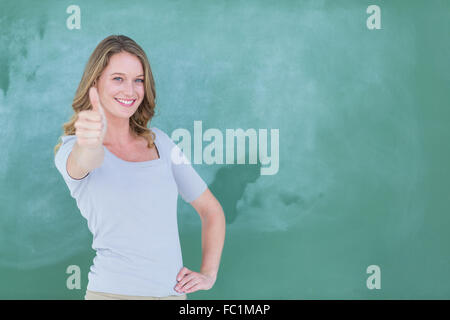 Smiling teacher standing Thumbs up in front of blackboard Banque D'Images