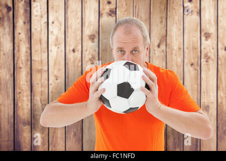 Image composite de football fan nerveux holding ball Banque D'Images