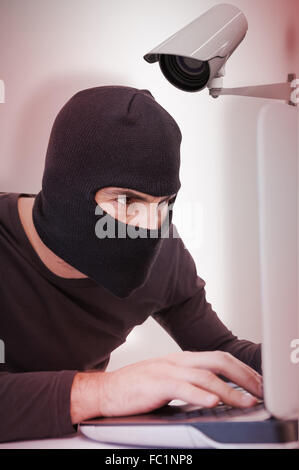 Composite image of burglar piratant coffre Banque D'Images