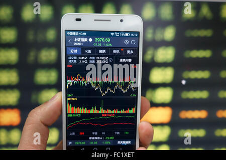 L'utilisation d'un investisseur téléphone mobile pour afficher des informations relatives aux actions en bourse à Huaibei, la province de l'Anhui, est de la Chine le 20 mai 2016. Shanghai Composite Index a diminué de 31,3 points ou 1,04 % à 2976.44 Le mercredi 20 janvier à partir de 3007.74 dans la précédente séance de négociation. Avec le recul, l'indice composite de Shanghai a perdu 6,20  % 196,6 points ou au cours des derniers 12 mois à partir de 3 173,05 points en Janvier de 2015. Banque D'Images