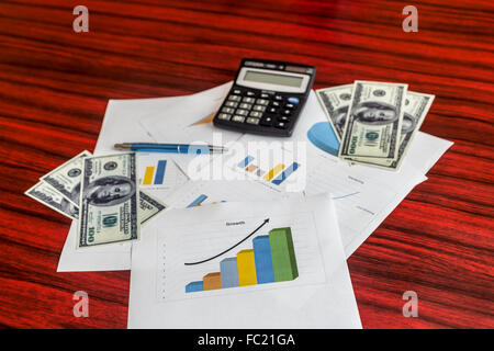 Groupe d'impression de graphiques avec des dollars, calculatrice et stylo sur eux Banque D'Images