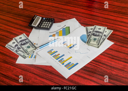 Groupe d'impression de graphiques avec des dollars, calculatrice et stylo sur eux Banque D'Images