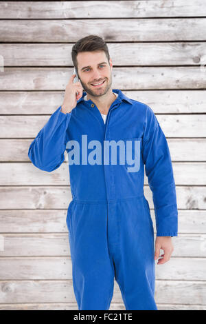 Portrait of male mechanic using mobile phone Banque D'Images
